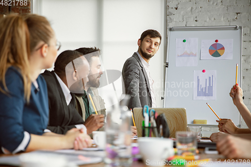 Image of Group of young business professionals having a meeting, creative office