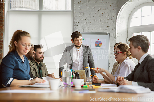 Image of Group of young business professionals having a meeting, creative office