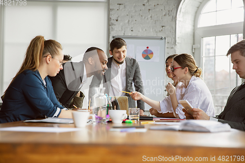 Image of Group of young business professionals having a meeting, creative office