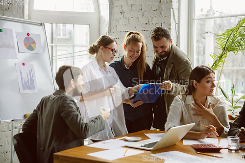 Image of Group of young business professionals having a meeting, creative office