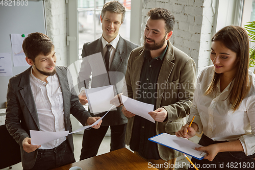 Image of Group of young business professionals having a meeting, creative office