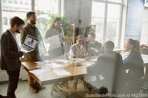 Image of Group of young business professionals having a meeting, creative office