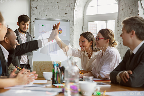 Image of Group of young business professionals having a meeting, creative office