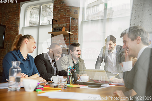Image of Group of young business professionals having a meeting, creative office