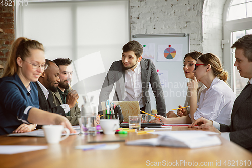 Image of Group of young business professionals having a meeting, creative office