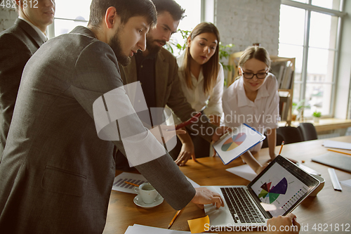 Image of Group of young business professionals having a meeting, creative office