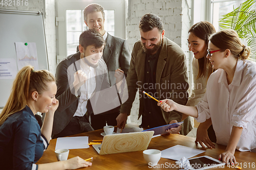 Image of Group of young business professionals having a meeting, creative office