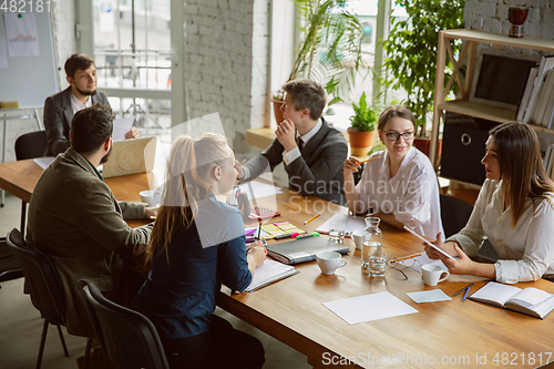 Image of Group of young business professionals having a meeting, creative office