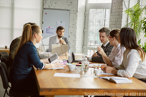 Image of Group of young business professionals having a meeting, creative office