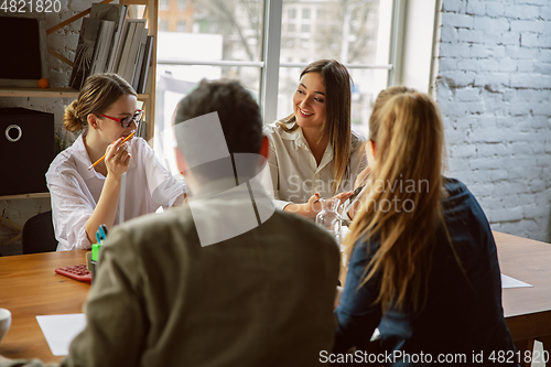Image of Group of young business professionals having a meeting, creative office