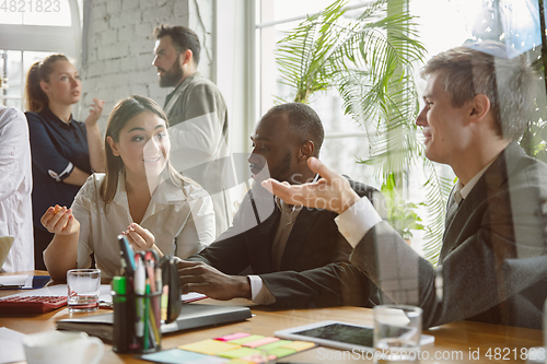 Image of Group of young business professionals having a meeting, creative office