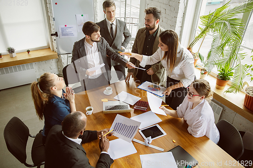 Image of Group of young business professionals having a meeting, creative office