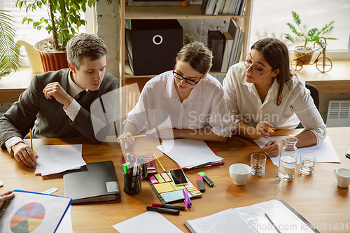 Image of Group of young business professionals having a meeting, creative office