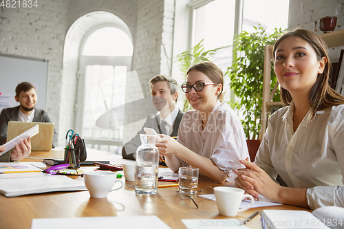 Image of Group of young business professionals having a meeting, creative office