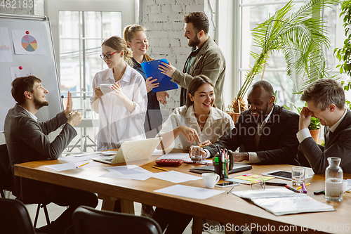 Image of Group of young business professionals having a meeting, creative office