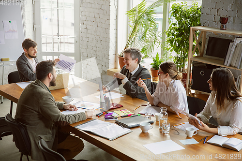 Image of Group of young business professionals having a meeting, creative office