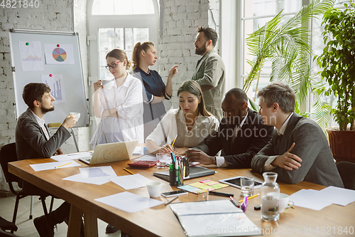 Image of Group of young business professionals having a meeting, creative office