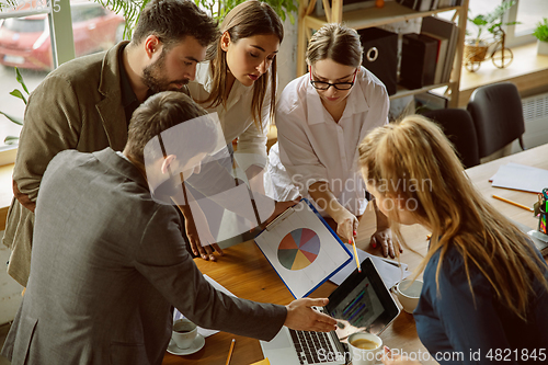 Image of Group of young business professionals having a meeting, creative office