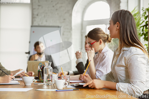 Image of Group of young business professionals having a meeting, creative office