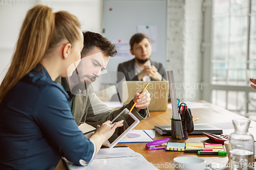 Image of Group of young business professionals having a meeting, creative office