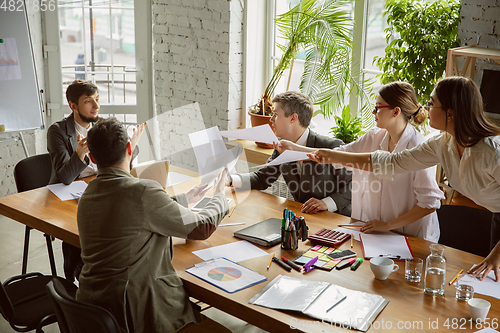 Image of Group of young business professionals having a meeting, creative office