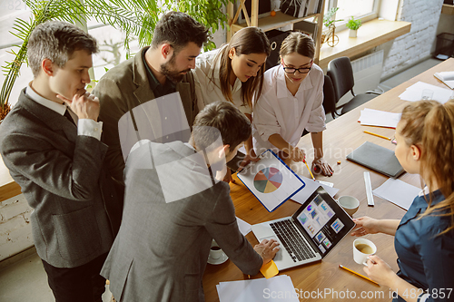 Image of Group of young business professionals having a meeting, creative office