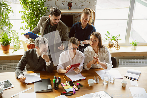 Image of Group of young business professionals having a meeting, creative office