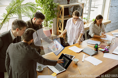 Image of Group of young business professionals having a meeting, creative office