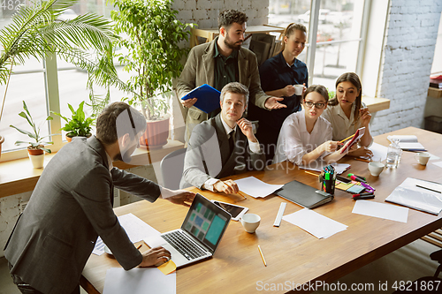 Image of Group of young business professionals having a meeting, creative office