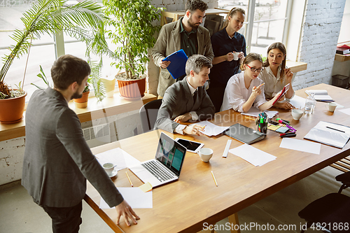 Image of Group of young business professionals having a meeting, creative office