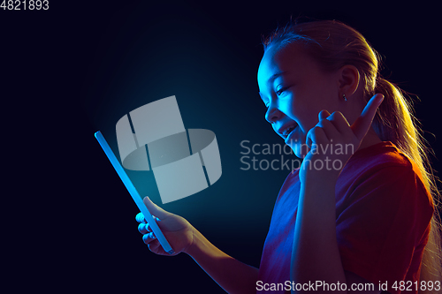 Image of Caucasian girl\'s portrait isolated on dark studio background in neon light