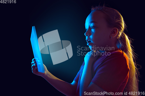 Image of Caucasian girl\'s portrait isolated on dark studio background in neon light
