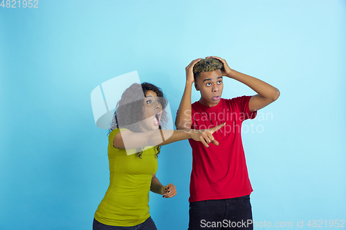 Image of Young emotional african-american man and woman on blue background