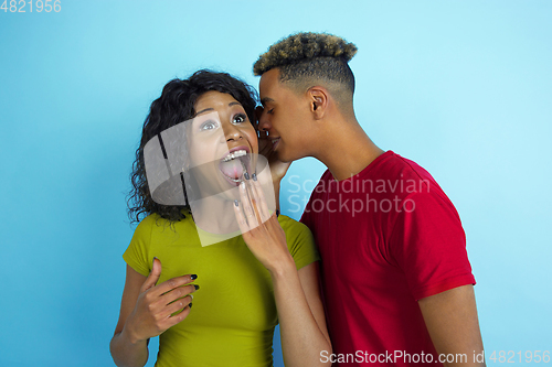 Image of Young emotional african-american man and woman on blue background