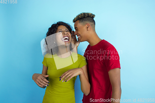 Image of Young emotional african-american man and woman on blue background