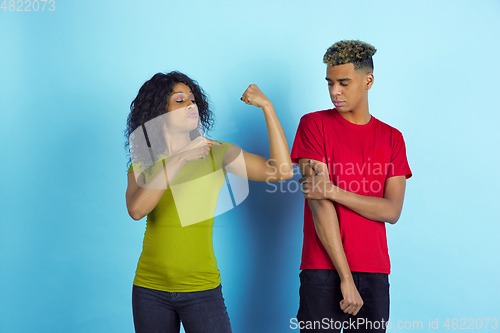 Image of Young emotional african-american man and woman on blue background