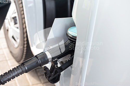 Image of White clean car refueling on a petrol station