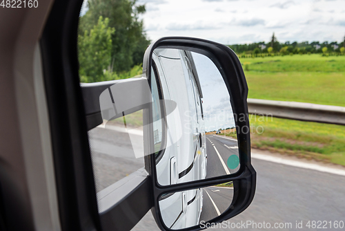 Image of Road view from the side mirror. Traveling by car