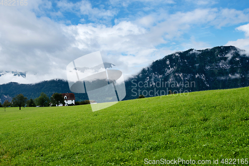 Image of Beautiful green mountains landscape in Switzerland Alps. Small house