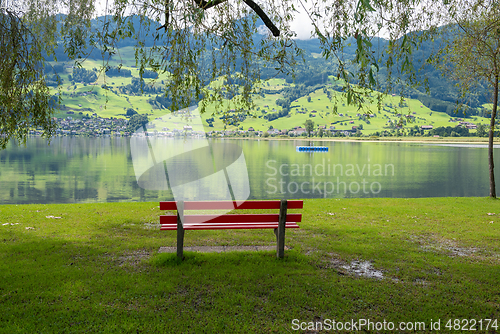 Image of A calm place to rest and relax. An empty wooden bench. Switzerland