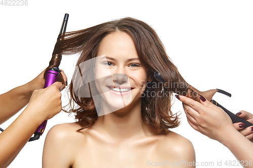 Image of beautiful girl getting hair and makeup