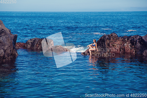 Image of beautiful girl resting in natural ocean swimming pool