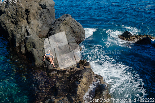 Image of beautiful girl resting in natural ocean swimming pool