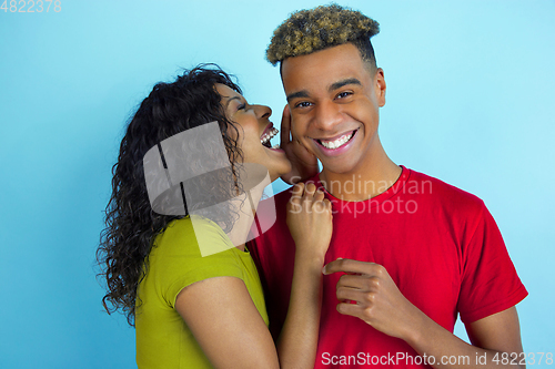 Image of Young emotional african-american man and woman on blue background