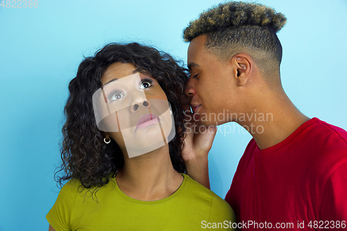 Image of Young emotional african-american man and woman on blue background