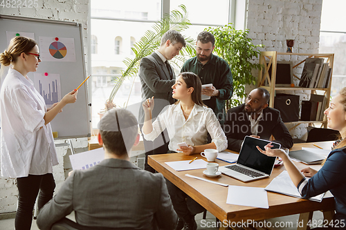 Image of Group of young business professionals having a meeting, creative office