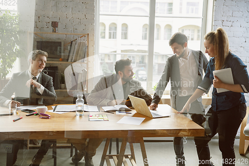 Image of Group of young business professionals having a meeting, creative office