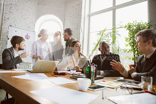 Image of Group of young business professionals having a meeting, creative office
