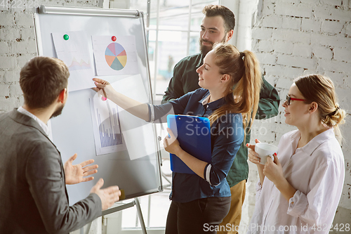 Image of Group of young business professionals having a meeting, creative office