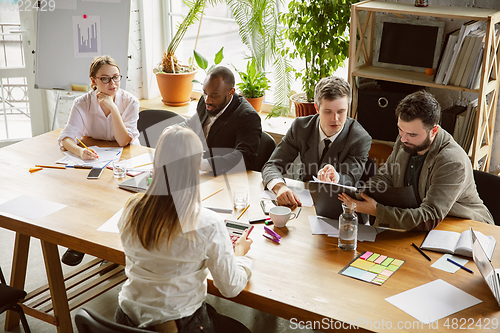 Image of Group of young business professionals having a meeting, creative office